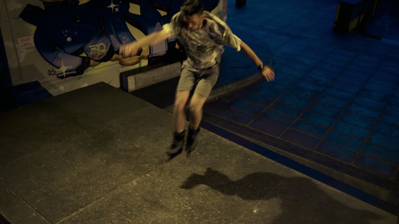 hombre deportivo realizando un truco de salto a través de escalones en patines en el parque de patinaje.
