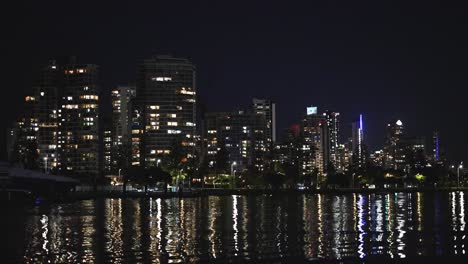 city skyline and lights reflecting on water at night