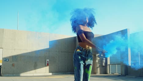 young woman dancing outside with smoke grenade at sunset on rooftop parking garage