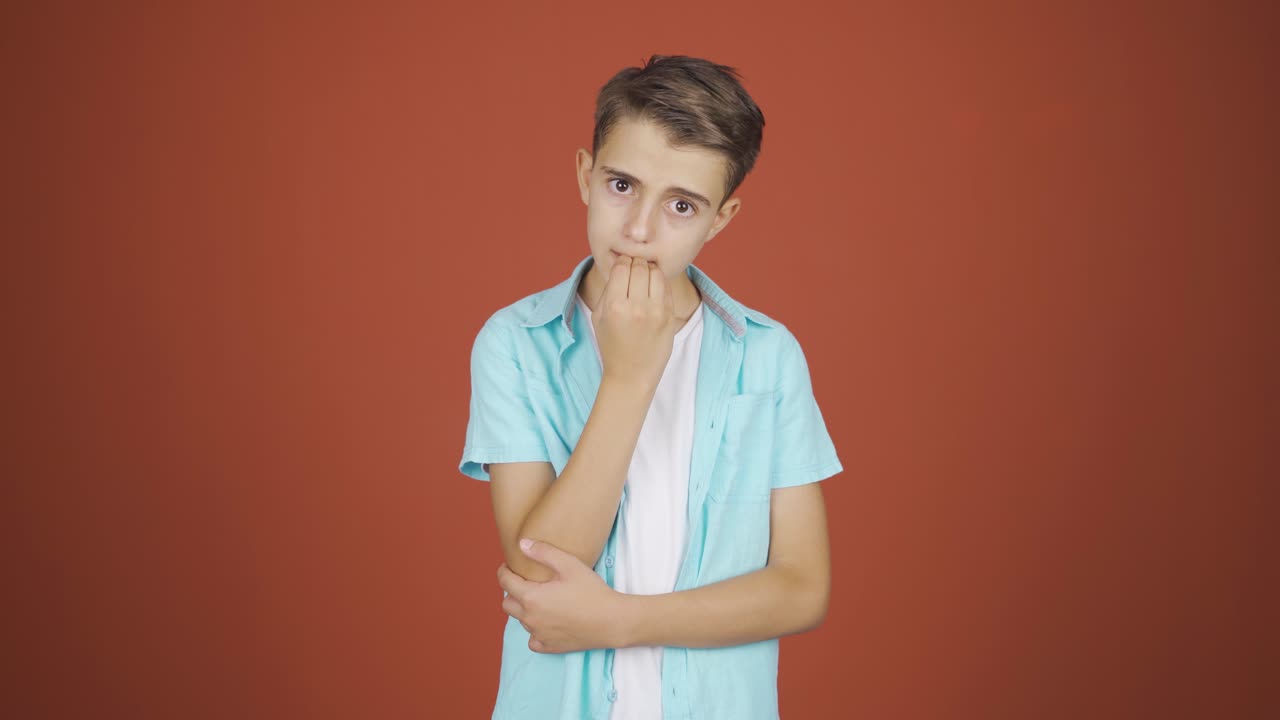 el chico se está mordiendo las uñas.