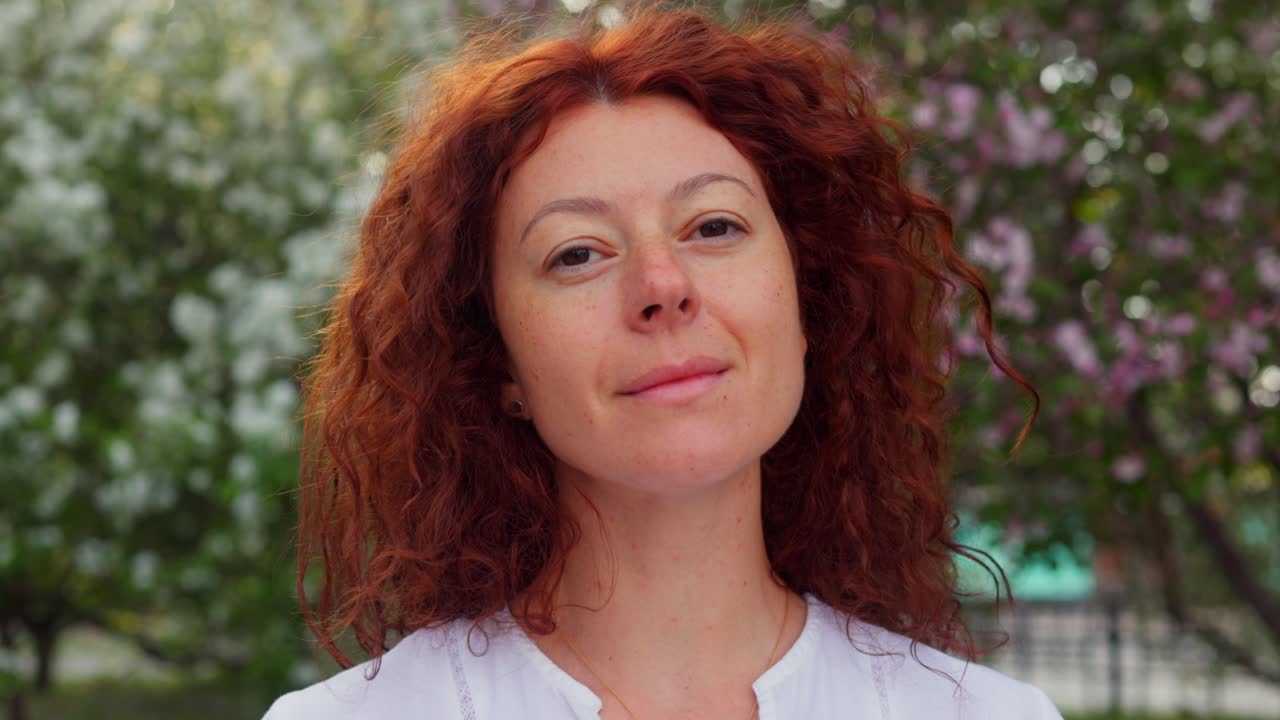 Woman with Red Curly Hair in a Spring Park