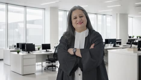 Happy-Indian-senior-female-lawyer-standing-crossed-hands