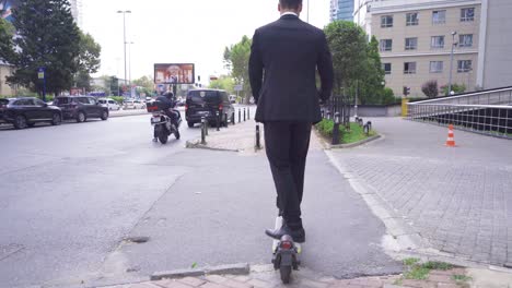 hombre en traje formal montando scooter eléctrico en la ciudad.