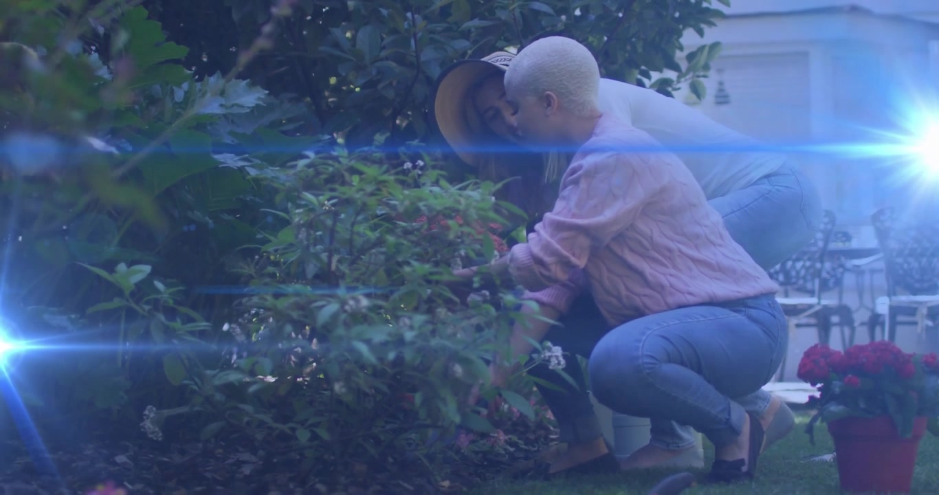 Two friends inspecting foliage and planting geraniums in backyard gardening tutorial