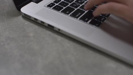 Trabajando-Con-Computadora-Portátil.-Vista-Lateral-De-Primer-Plano-De-Manos-Femeninas-Escribiendo-En-El-Teclado-Del-Portátil.