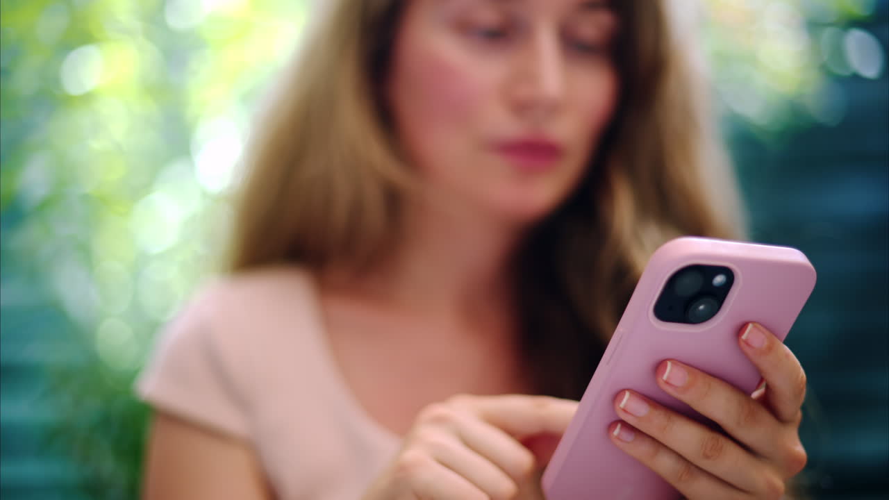 Brunette woman scrolling on the phone outside in daylight