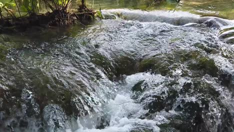 Vista-Inclinada-Del-Agua-Cayendo-En-Cascada-A-Lo-Largo-De-Una-Superficie-Rocosa-En-Un-Charco-De-Burbujas-En-El-Parque-Nacional-De-Los-Lagos-De-Plitvice-En-Croacia,-Europa-A-¼-De-Velocidad