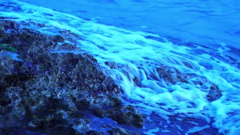 la ola del mar corre en cámara lenta sobre una pequeña roca en la costa del sur de francia por la noche