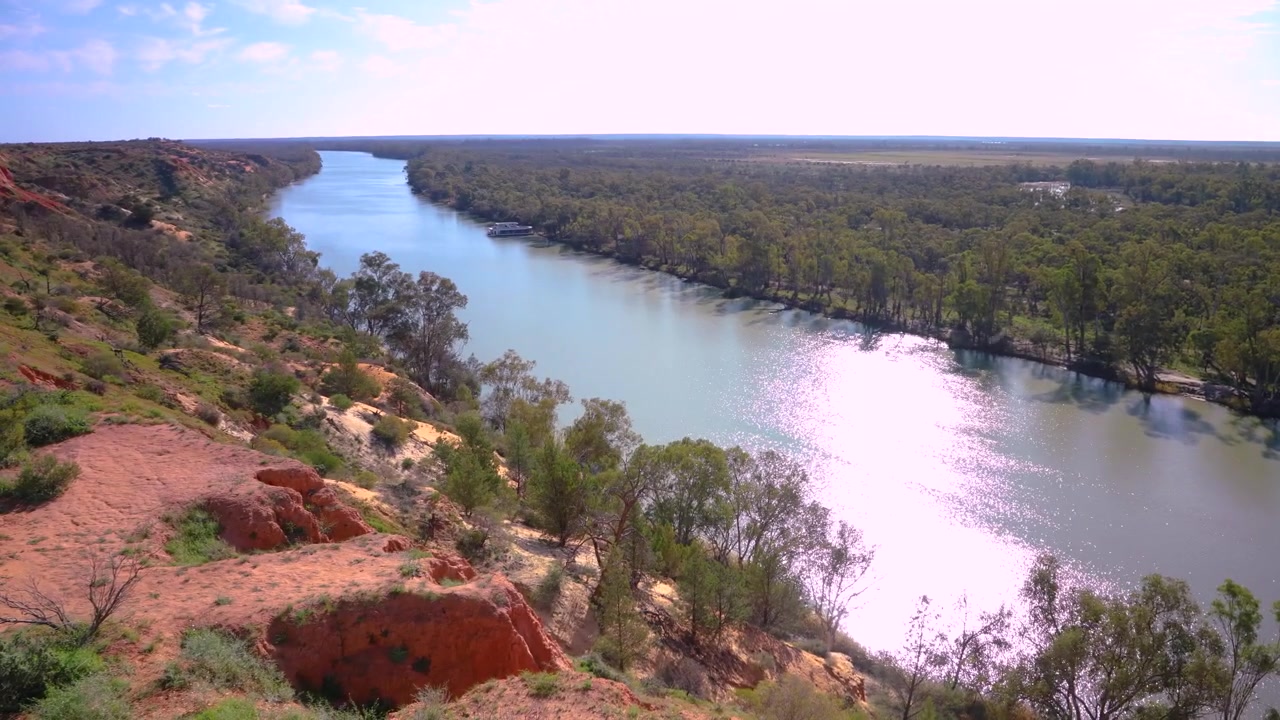 Landschaft am Murray River mit roten Klippen und Hausbooten, australische Natur und Umweltschutz. Die Weitwinkelaufnahme zeigt die ruhige Wasserstraße, zerklüftete Klippen und das umliegende Buschland