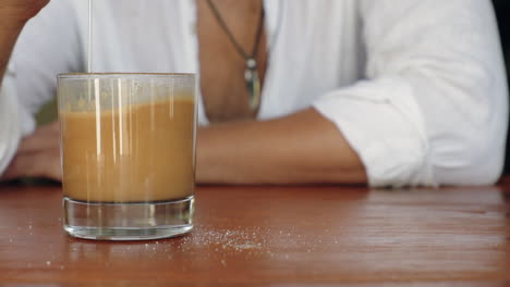 hombre espumando un café con espumador de leche eléctrico