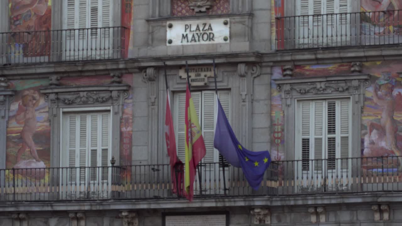 Bandiera spagnola e dell'UE che sventola leggermente sotto l'insegna di Plaza Mayor a Madrid, Spagna.