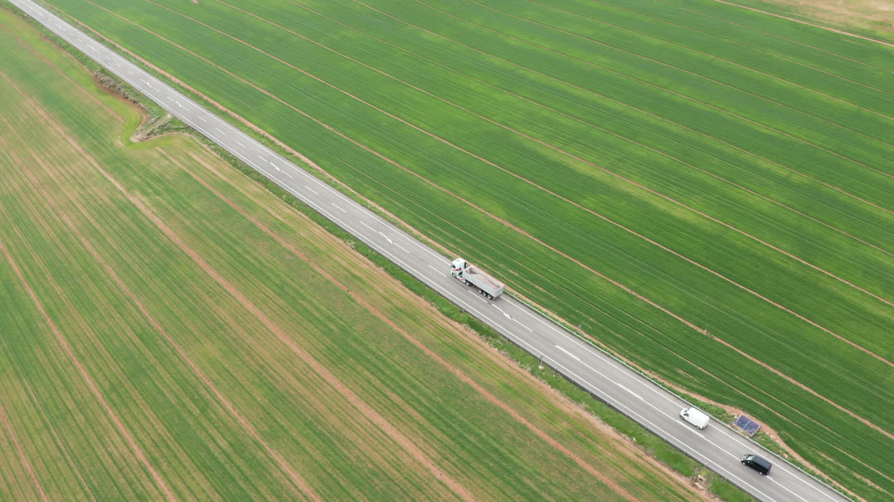 트럭과 자동차가 도로를 지나가는 녹색 잔디 스페인 농학 농경지