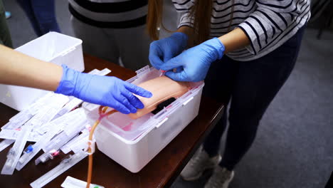 doctor in gloves making injection with a syringe for puncture. simulation medical training model. medical procedure concept, simulation medicine training.