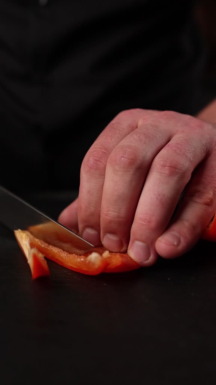 el chef cortando un pimienta roja