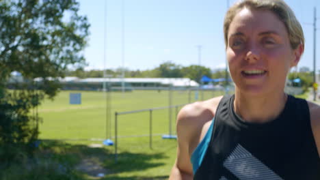 atleta rubia de cerca corriendo al aire libre en la acera, cámara lenta de 4k