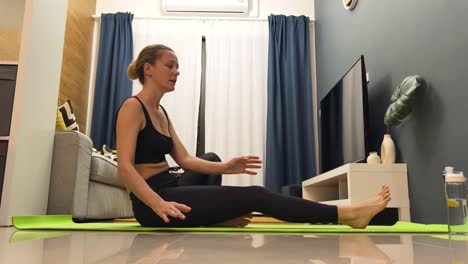 mujer practicando yoga y estiramiento en casa