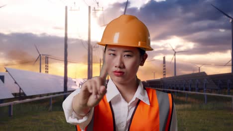 close up of asian female engineer with safety helmet disapproving with no index finger sign with solar panel and wind turbines