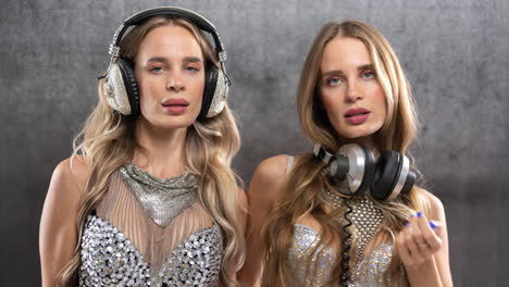 identical twin female dancers in sparkling silver costumes