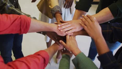 diversas personas de negocios que se unen con las manos juntas en la oficina