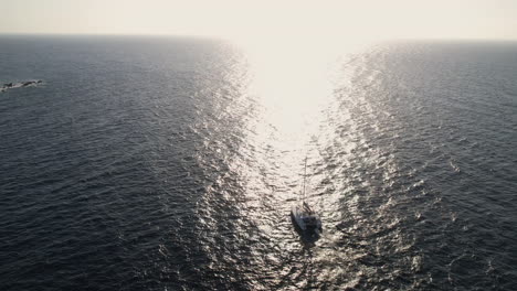 vista aérea del catamarán navegando en el mar egeo por la isla de santorini, grecia en la hora dorada del sol.