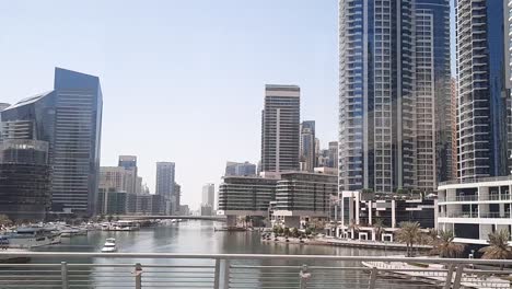Passenger-vehicle-side-view-of-the-dubai-high-rise-buildings-and-the-lake-cityscape