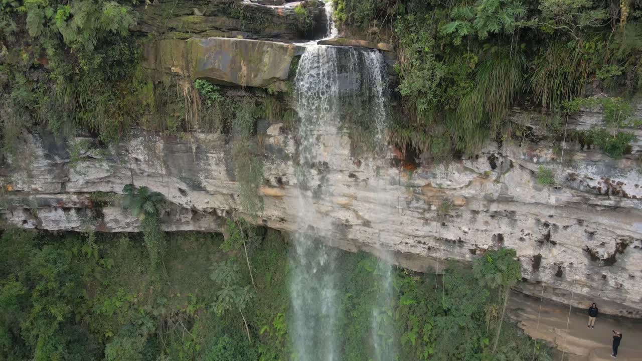 volando hacia el agua que fluye por las cascadas en brasil con turistas en el punto de observación