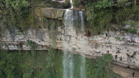 volando hacia el agua que fluye por las cascadas en brasil con turistas en el punto de observación