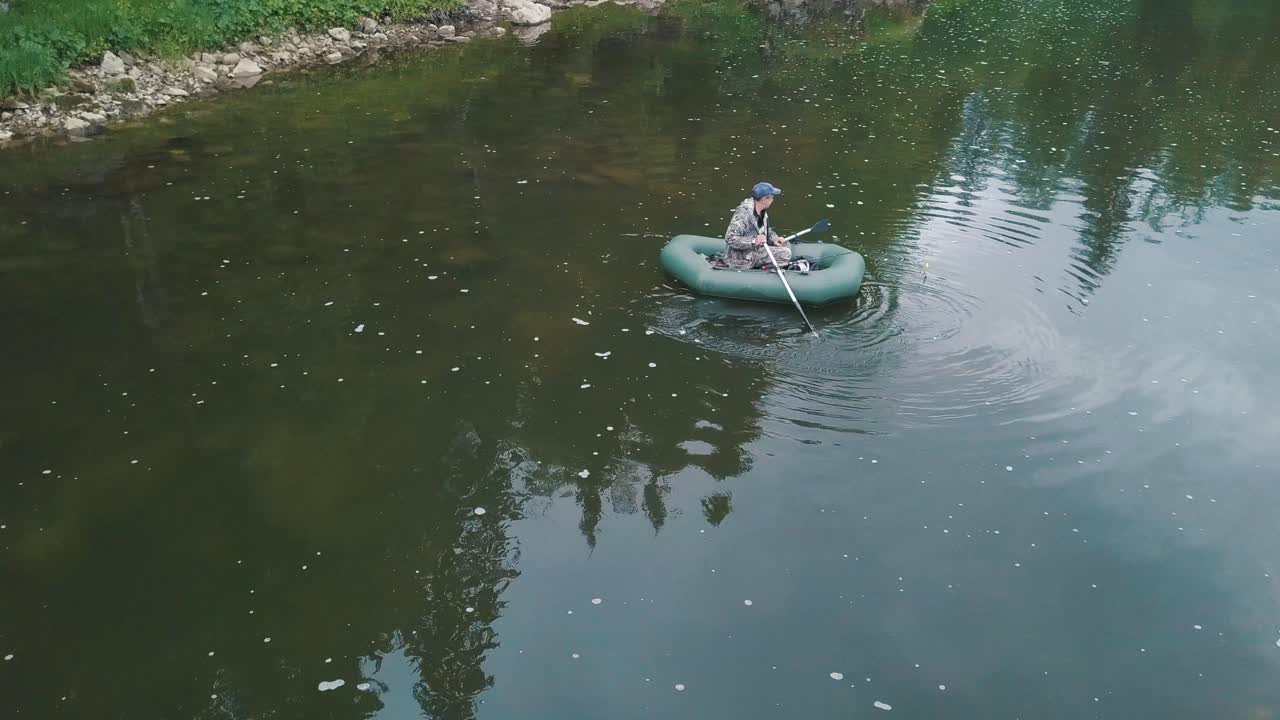 hombre pescando desde un barco inflable en un río