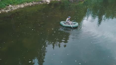 man fishing from inflatable boat on a river