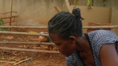 a close up shot of an african woman's face as she digs the soil in a rural farm with a hoe