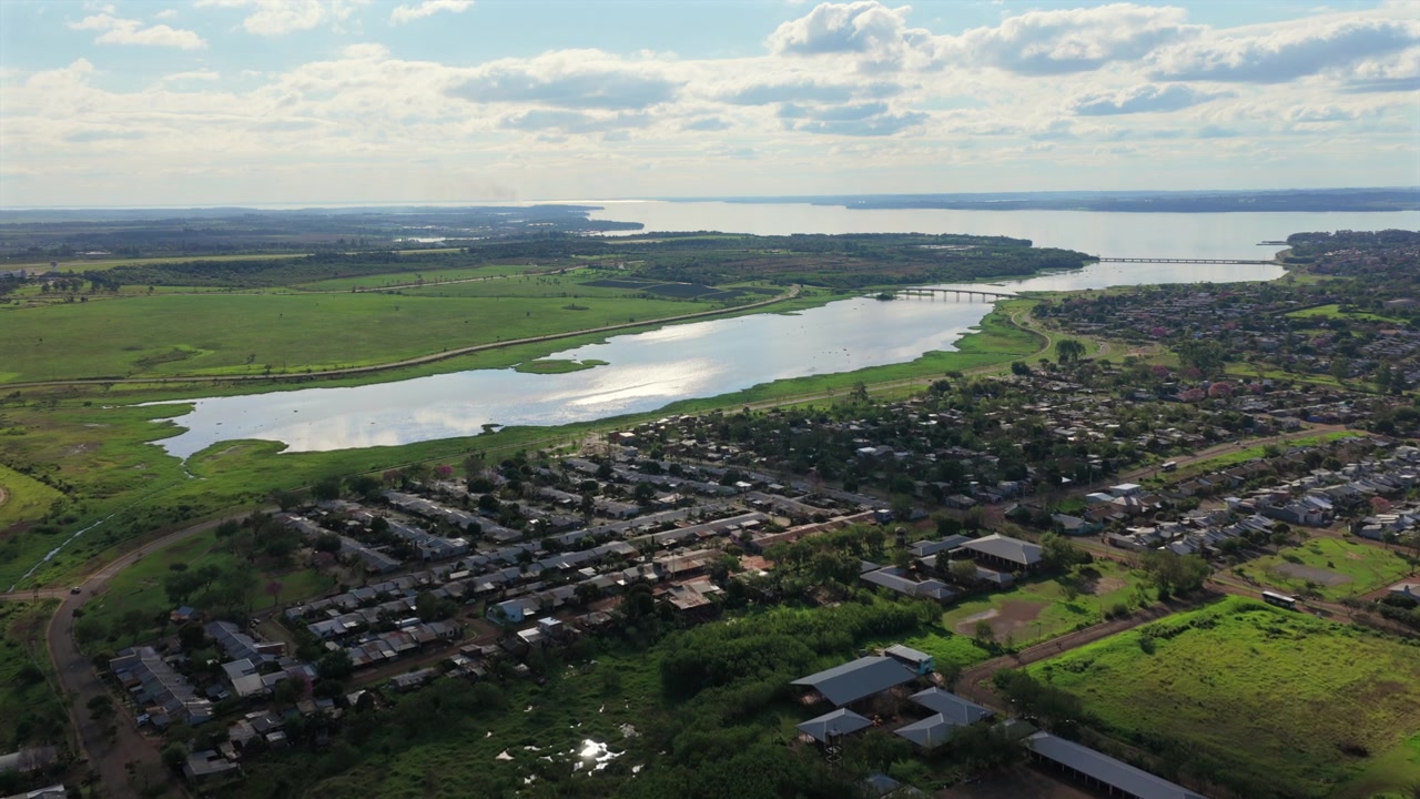 Riprese aeree con drone mostrano il quartiere Costa Oeste a Posadas con una laguna e il fiume Paraná sullo sfondo.