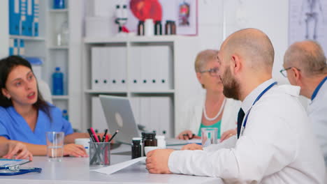 Arzt-überprüft-Liste-Der-Patienten-Während-Der-Medizinischen-Konferenz