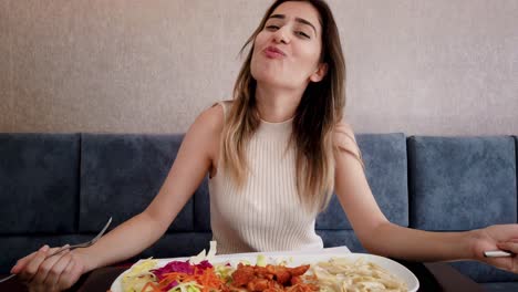 Beautiful-young-girl-eats-chicken-food-with-a-big-enjoy-in-a-restaurant-or-cafe-while-sitting