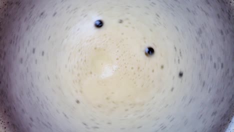 coffee foam swirling in a cup - close up, top shot