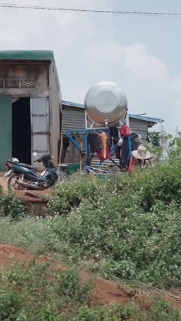 rural scene with house, motorcycle, water tank, and clothesline