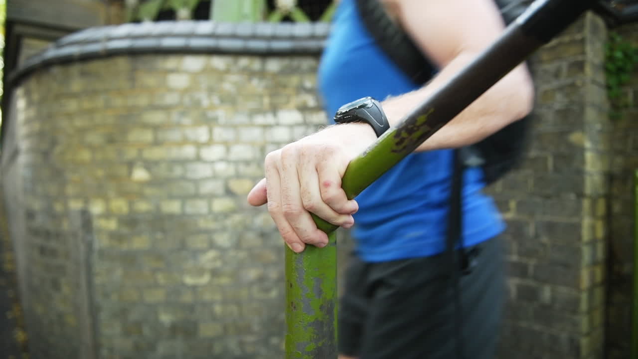 An adult man runs down the stairs of a subway quickly grabbing the railling to balance while turning