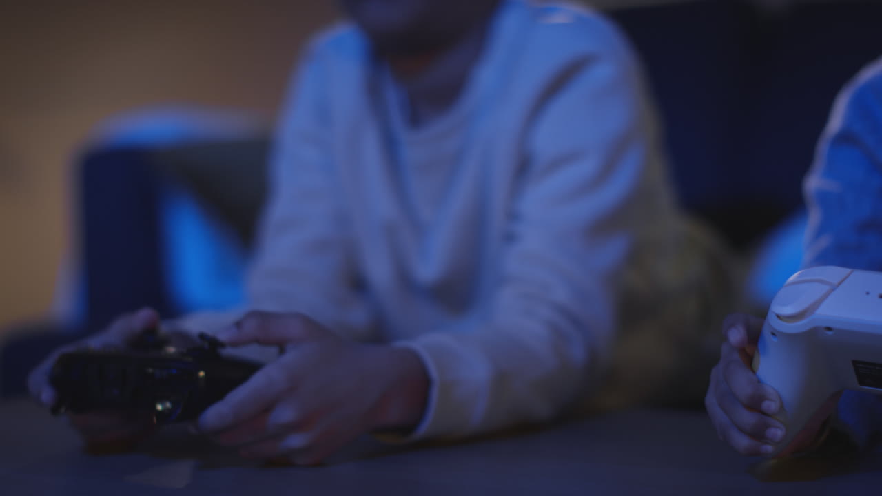 cerca de dos niños pequeños en casa jugando con consola de juegos de computadora en la tv sosteniendo controladores tarde en la noche 5