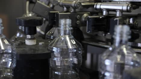 Close-Up-of-Empty-Vinegar-Bottles-at-a-Factory-Rotating-Under-Automated-Machinery