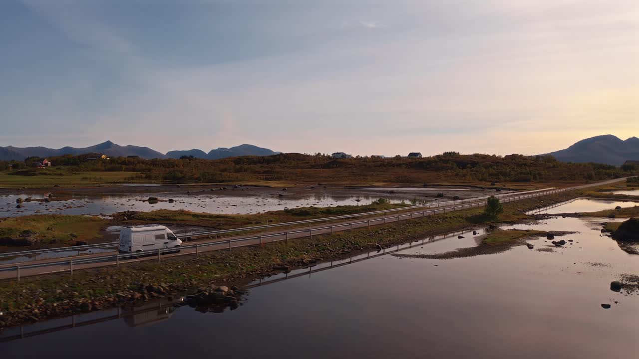 Serene shot of a van driving along a scenic road by the water in Vestarelen, Norway
