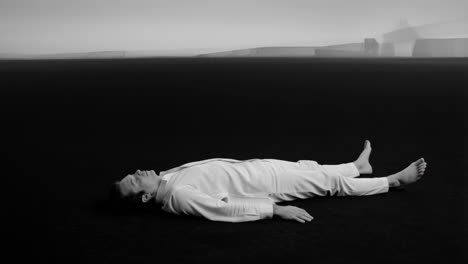 monochrome portrait of a man lying on dark ground