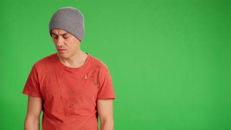 Sad homeless man looking at camera on green screen background