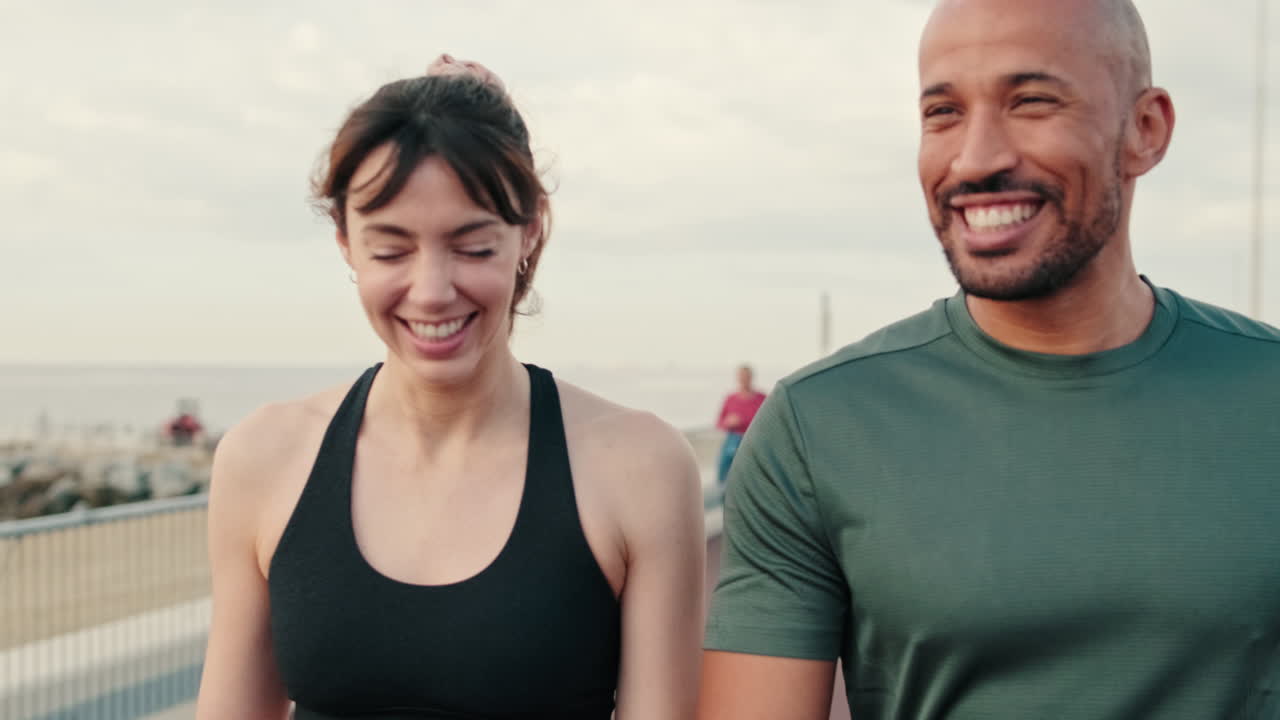 Cheerful Couple Laughing While Walking on a Coastal Path