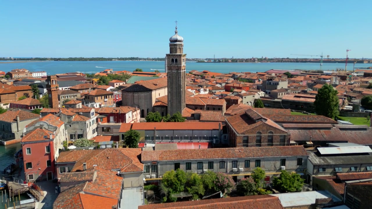 Vista aerea si sposta sopra i tetti di Murano verso la Chiesa di San Pietro Martire e il canale.