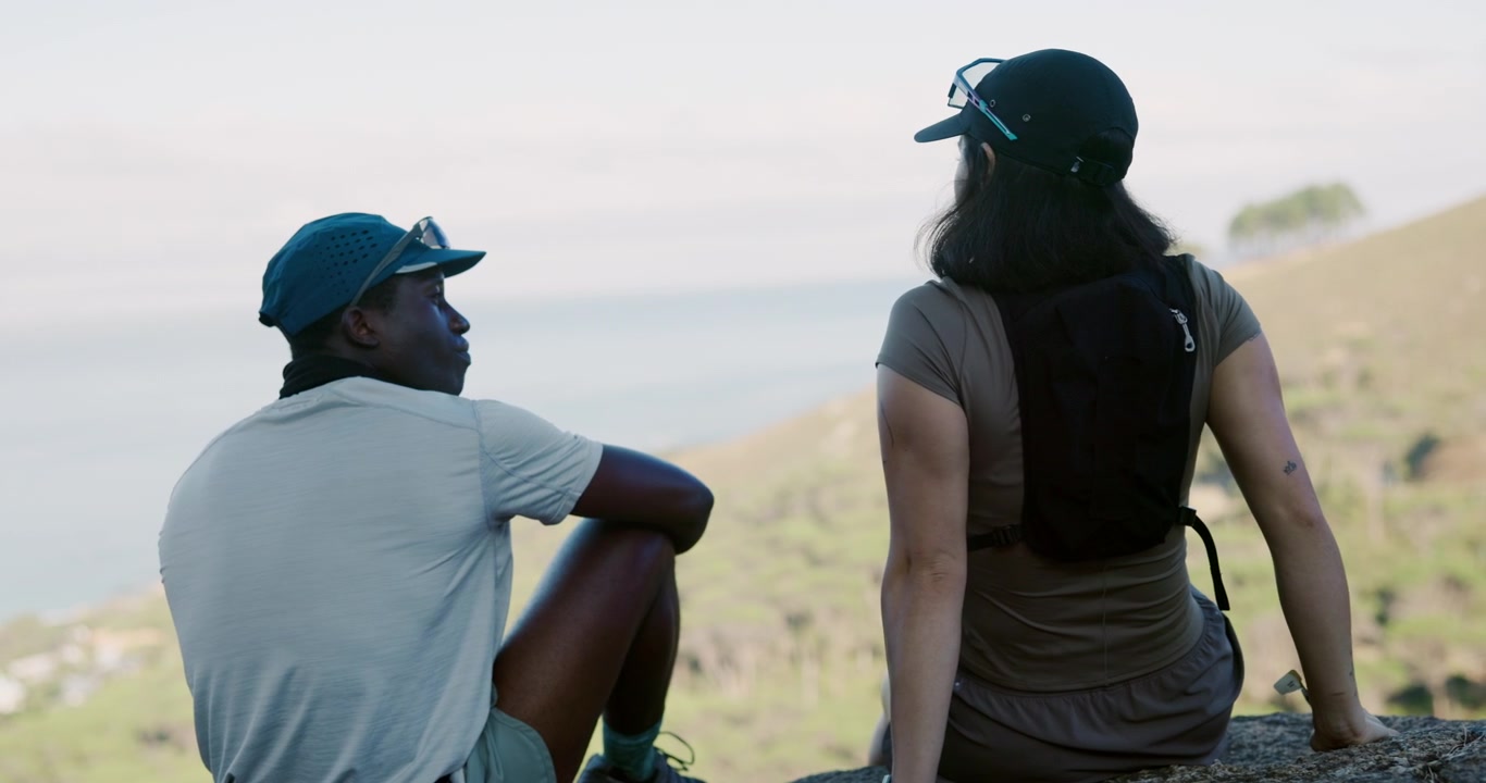 Two Hikers Resting on a Mountain Overlooking the Ocean