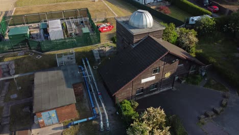 vista aérea pex hill leighton observatorio cúpula de plata techo en la cima de la colina tierras de cultivo al amanecer, ascendiendo inclinación hacia abajo