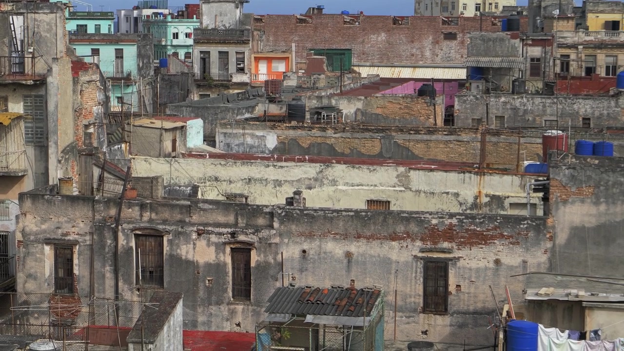 Condomini invecchiati dell'Avana Vecchia, Cuba, con muri sbiaditi, terrazze sui tetti ed edifici colorati ammassati strettamente, per temi di degrado urbano e viaggio, di giorno.