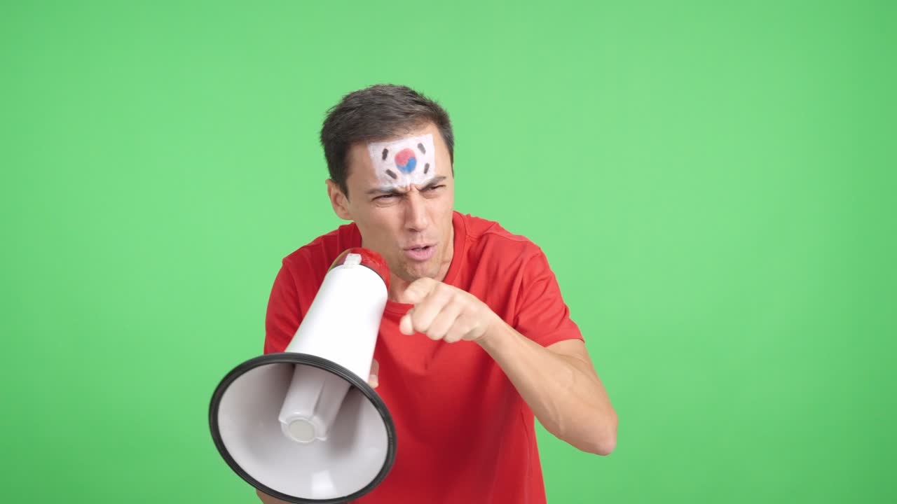 Excited man with south korean flag on face using a megaphone
