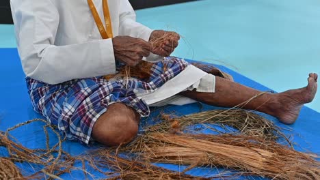 Ein-Arabischer-Fischer,-Der-Mit-Seiner-Hand-Aus-Palmfasern-Ein-Seil-Herstellt