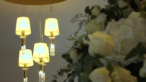 shot of beautiful wedding scenery, with a ceiling lamp and a boquet of roses