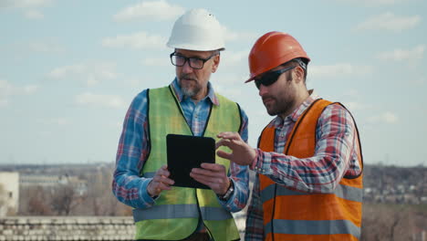 construction workers reviewing project on rooftop
